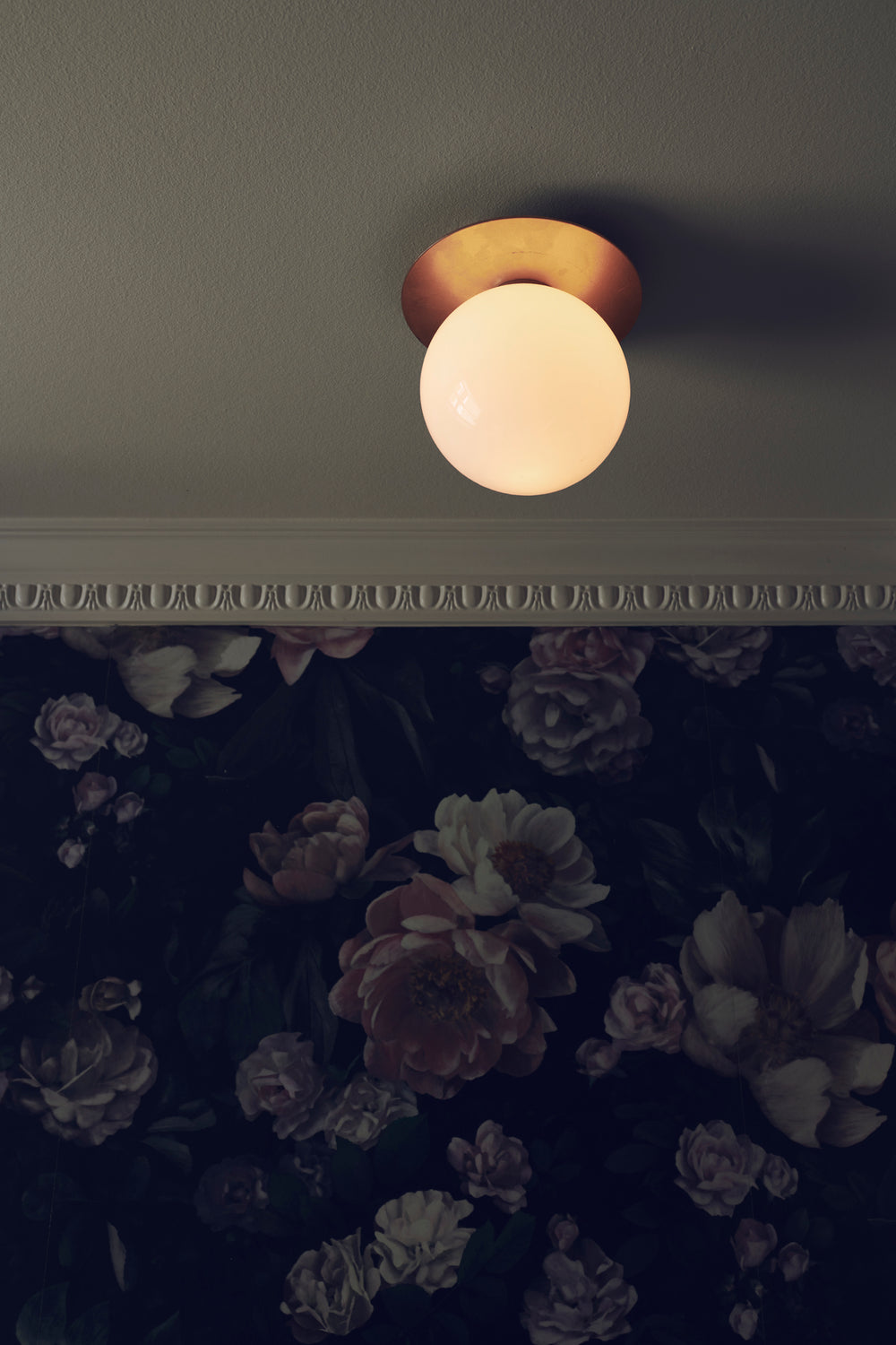 Loftlampe med lampeskærme af opalglas og gylden fatning, i dagligstuemiljø