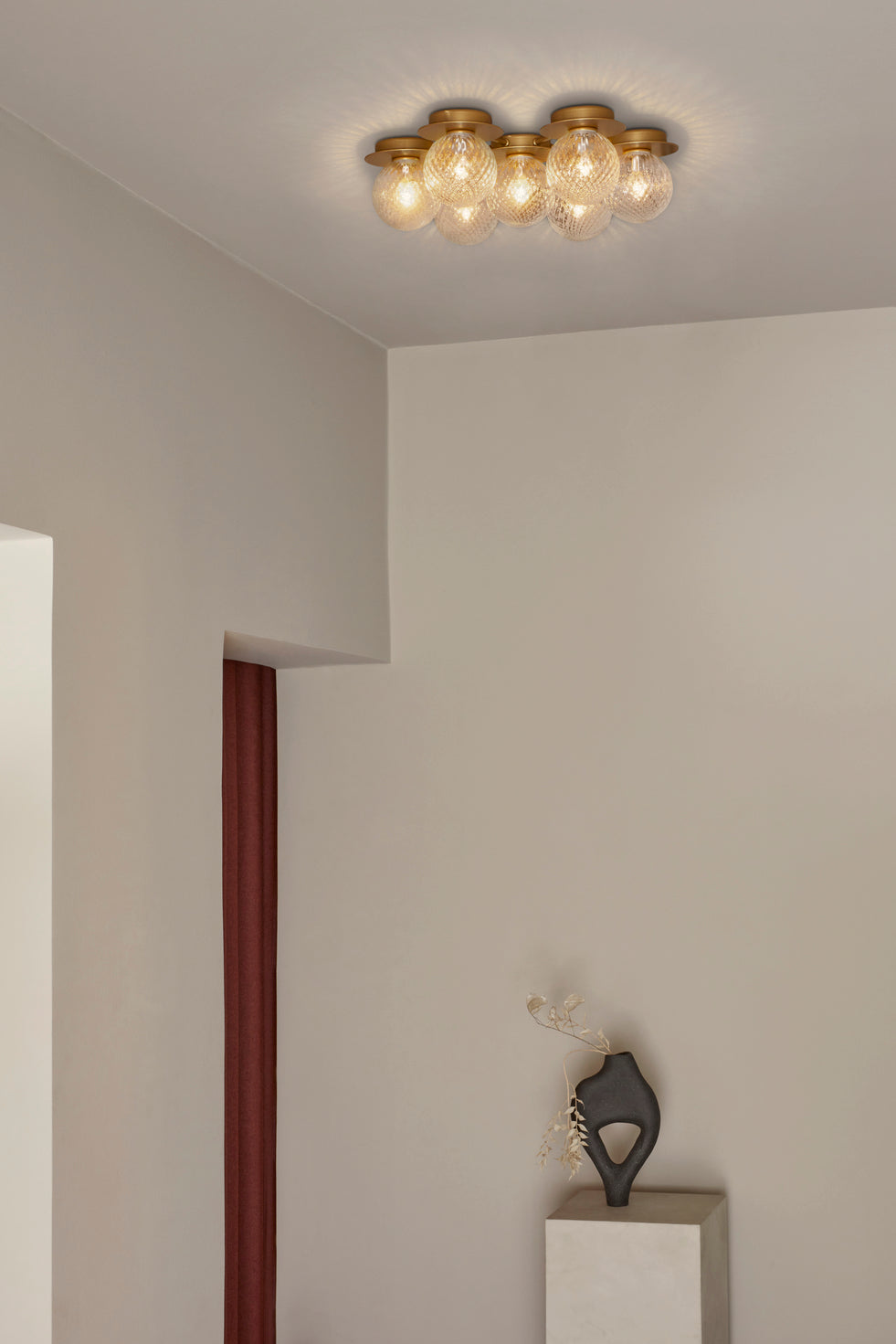 Loftlampe med lampeskærme af klart optikglas og gylden fatning og stel, på hvidt loft