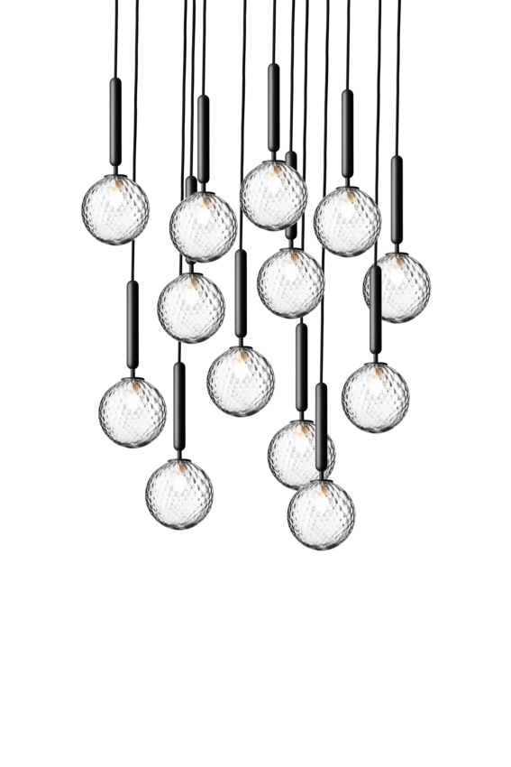 Pendel bestående af 13 runde skærme af klart optikglas med gråt ophæng og sort ledning, på hvid baggrund.