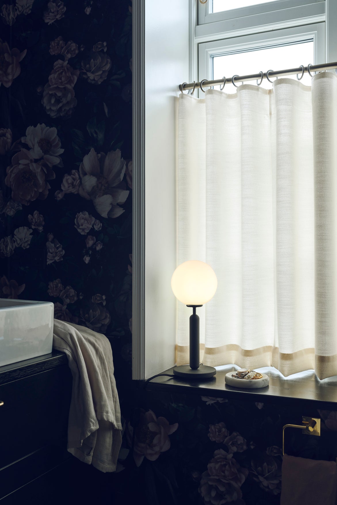 Bordlampe med rund skærm af opalglas og mørkegråt stel, på badeværelse