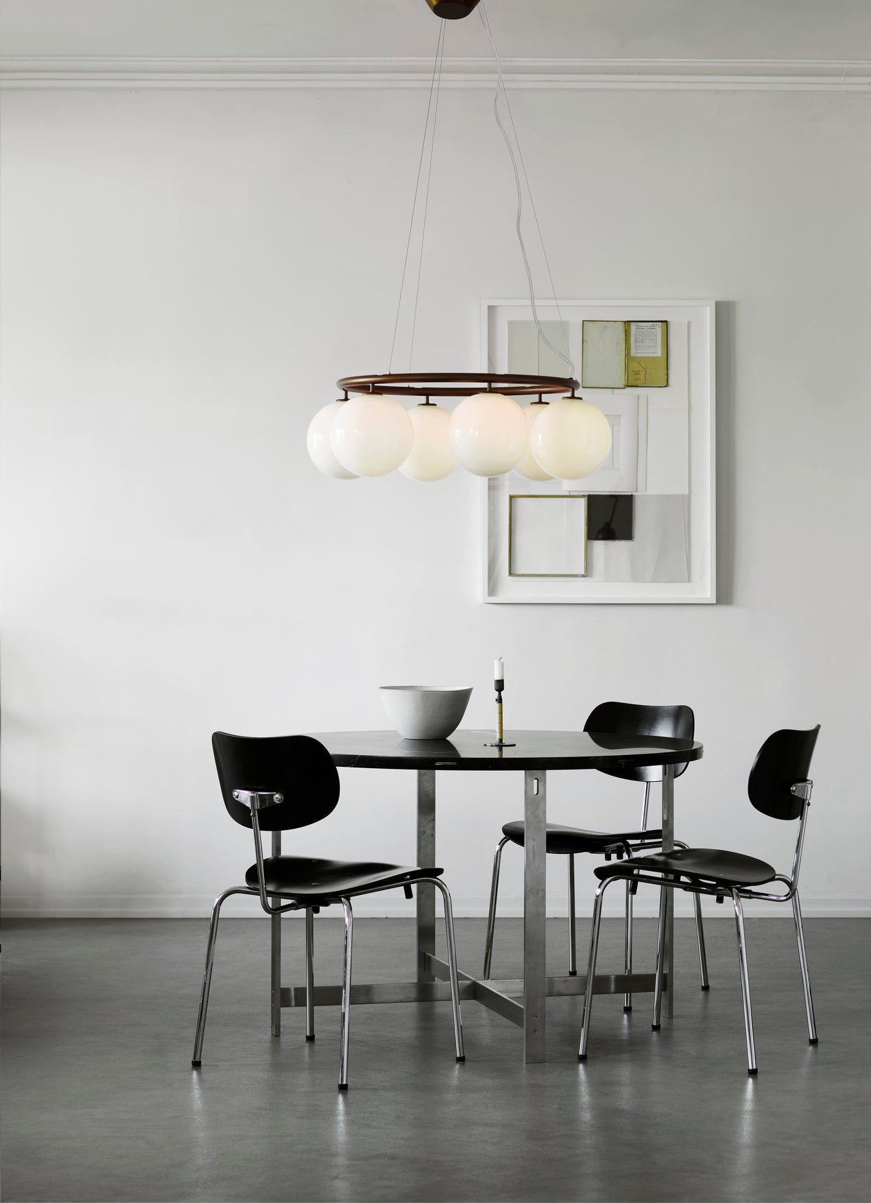 Lysekrone bestående af seks runde skærme i opalglas samt bruneret krone, i spisestuemiljø over spisebord