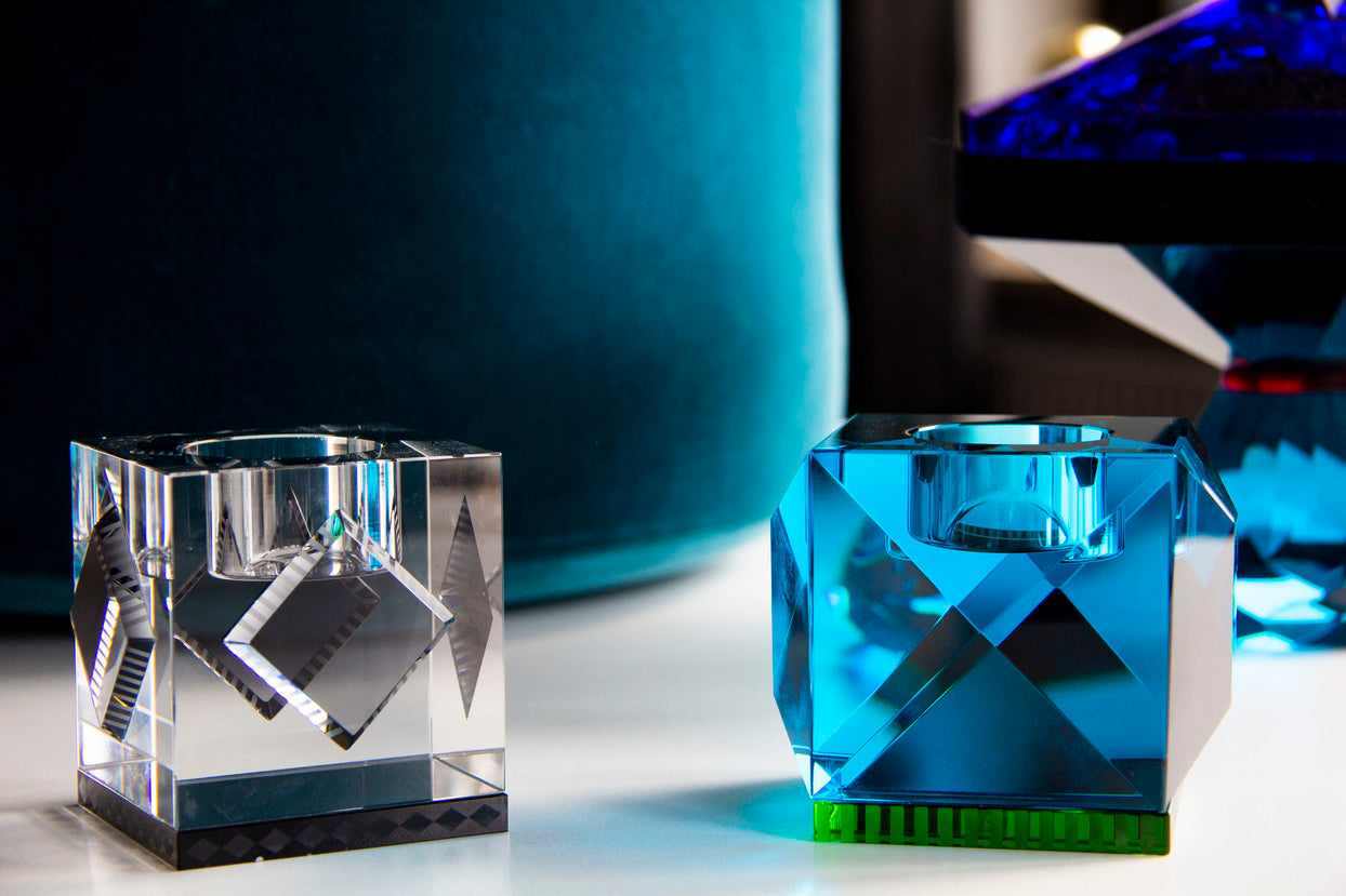Close-up af tre firkantede fyrfadsstager i farvet krystal.