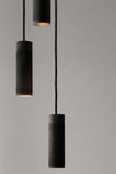 Nærbillede af loftlampe med tre pendler i massiv sort bruneret messing med sort stofledning 