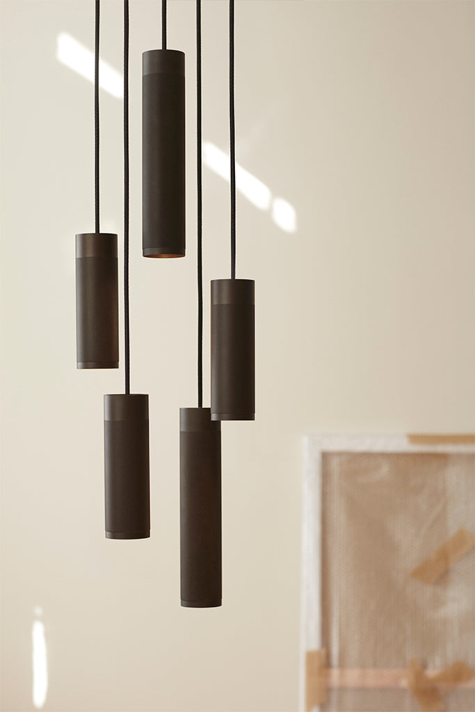 Stue med lofthængt pendel cluster lampe i massiv bruneret messing og sorte stof ledinger