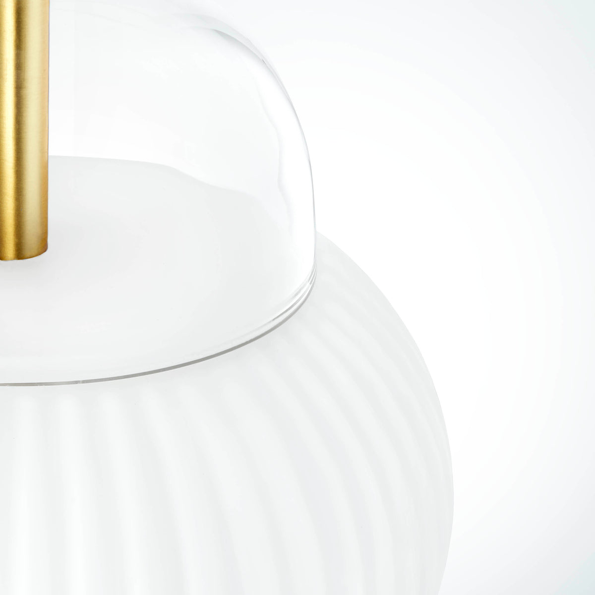 Lampe i klart glas og mat hvidt plisseret glas. Derudover har lampen detaljer i messing og en hvid stofledning. 