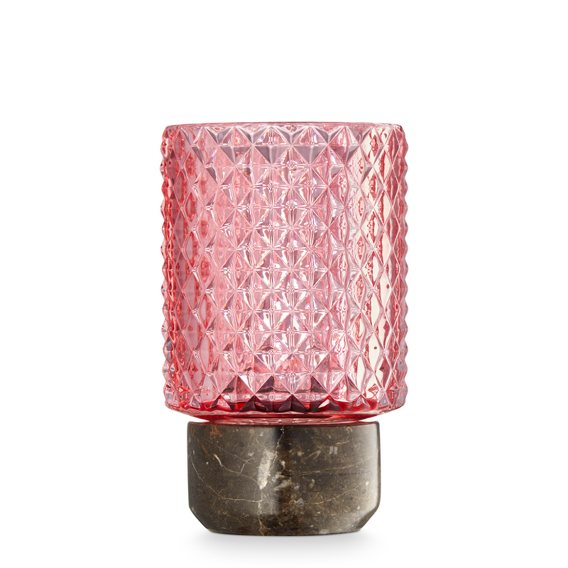 Fyrfadstage med brun marmor bund og en top i rosafarvet glas med mønster.