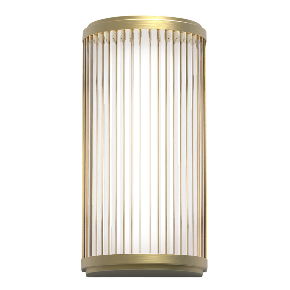 Lampe med top, bund og bagside i guldfarvet stål samt en glasskærm med nedadgående linjer.