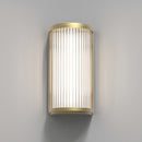 Lampe med top, bund og bagside i guldfarvet stål samt en glasskærm med nedadgående linjer.